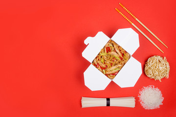 wok with chicken on red background