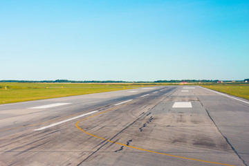 Travel aviation concept. Runway, airstrip in the airport terminal with marking on blue sky...