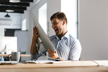 Cheerful male manager having fun with computer