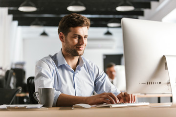 Image of Smiling business man using computer - Powered by Adobe