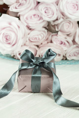 present gifts box. rose flowers and gift box with ribbon on light table. Greeting card for Birthday Womens or Mothers Day