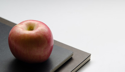 Red apple on the books and white background