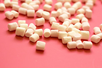 Obraz na płótnie Canvas white marshmallow on a pink background