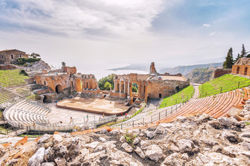 Ruins of the Greek Theater of Taormina and the picturesque mountain chain from the vulcano Etna to Castelmola in the background. Taormina, Sicily, Italy