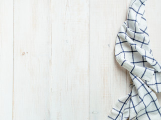View from above on white wooden table with linen kitchen towel or textile napkin. Blue tablecloth on white wood tabletop. Copy space for text. Can use as mock up for design.