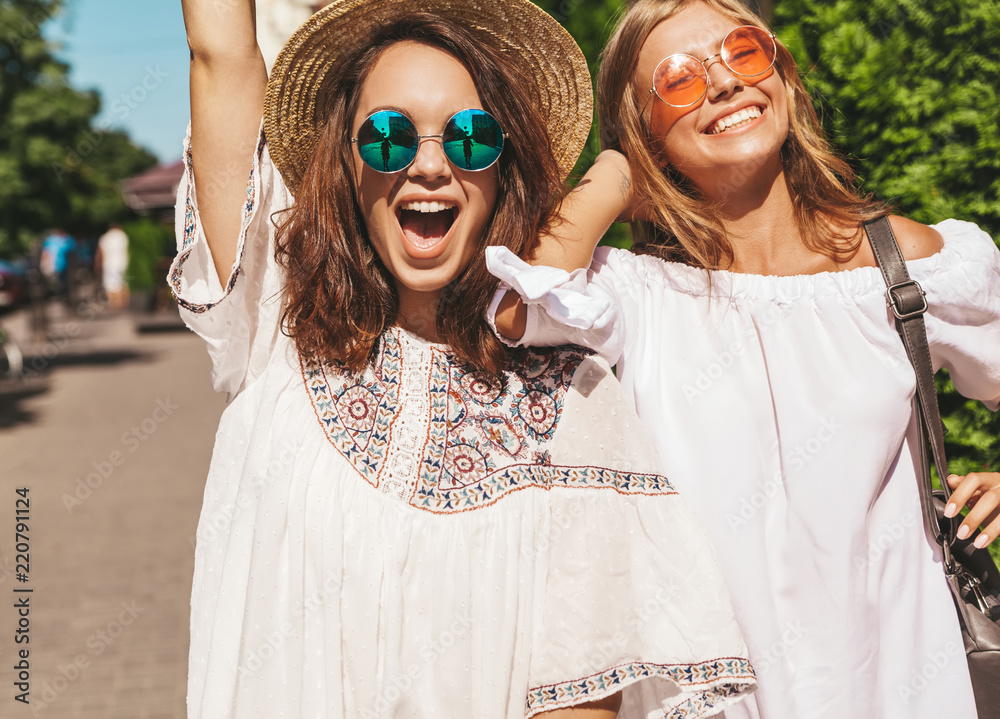 Wall mural fashion portrait of two young stylish hippie brunette and blond women models in summer sunny day in 