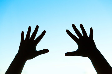 silhouette of woman's hands on blue background