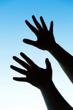 silhouette of woman's hands on blue background