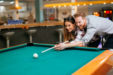 Couple flirting while playing snooker