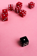Red and black gaming dices on pink background. Game concept.