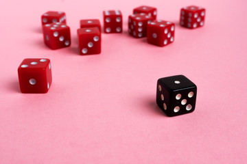 Red and black gaming dices on pink background. Game concept.