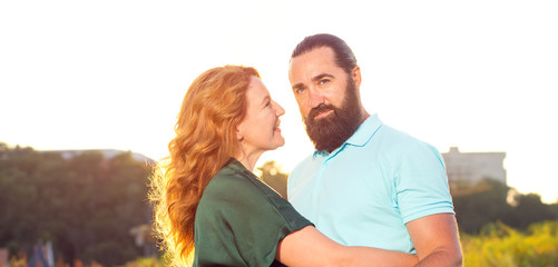 Happy adult couple man and woman on sunset background.