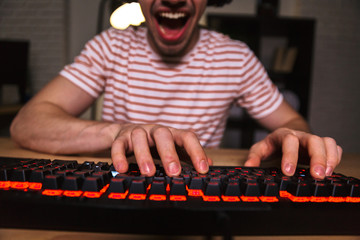 Cropped image of Cheerful gamer playing video games on computer
