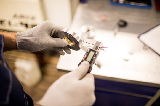 Engineer In Gloves Measuring Width Of Steel Detail With Calipers During Work In Factory