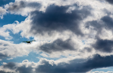 Light aircraft flying into cloudy sky in storm