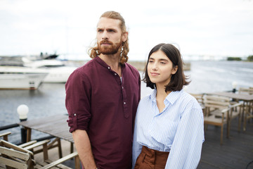 Obraz premium Young casual couple having rest in outdoor cafe by waterside on summer day