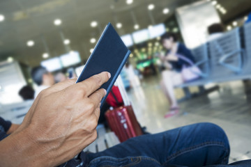 man reading a book in a station or airport