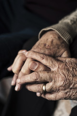 young man holding the hand of an old woman