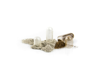 Flat lay view of two different color powder transparent gel capsules opened, powder spilled around, isolated on white. Pharmaceutical concept.