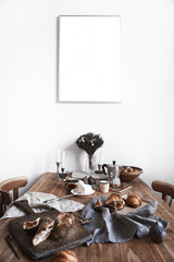 White kitchen interior with provence breakfast on wooden table, poster on the white wall, space for design layout.