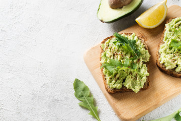 Two toasts with avocado and green salad on breakfast