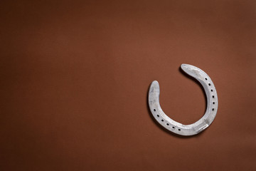 Single horseshoe isolated on a brown background
