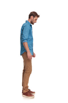 side view of a casual man looking down at something