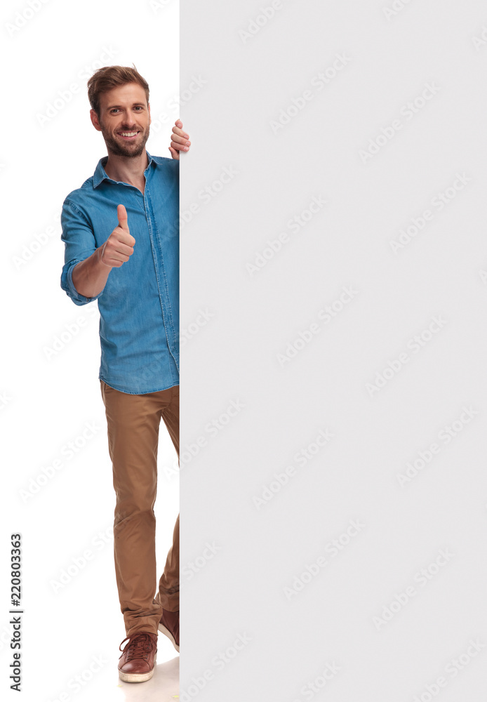 Canvas Prints smiling casual man presenting  billboard and makes the ok sign