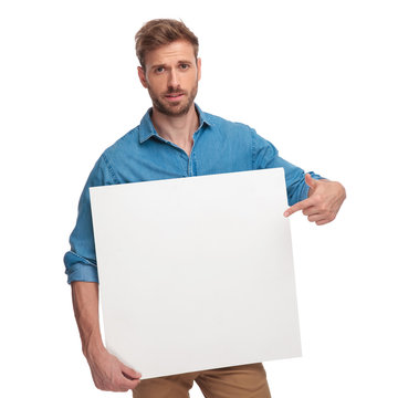 Young Casual Man Pointing Finger At A Blank Board