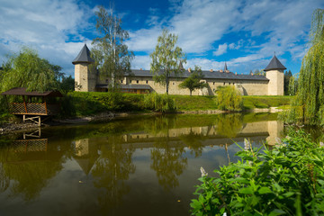 Monastery in Sucevita on shore of pond, Romania