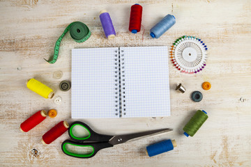 Sewing accessories and an open notebook