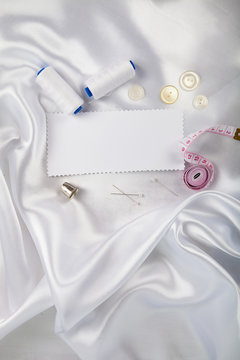 Sewing accessories and a note on white satin fabric
