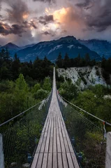 Fototapeten Evening shot of a wooden hanging bridge near the towns Susten and Leuk in Canton Wallis © Rik