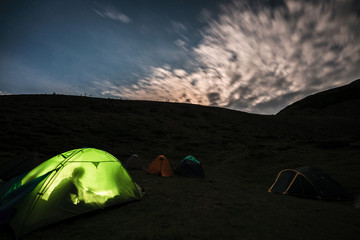 Tourists rest at night in tents under the starry sky in the mountains. Carpathians, Ukraine