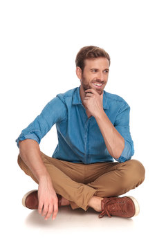 man sitting down laughs and thinks