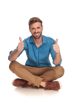 young casual man is sitting and making the ok sign