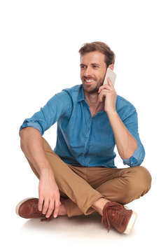 seated man  is talking on the phone and looks away