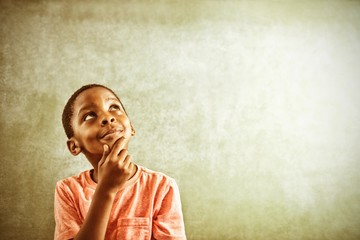 Thoughtful boy against greenboard