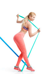 Fit young pretty woman exercises with stretch bands.