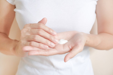 Woman applying moisturizing cream/lotion on hands, beauty concept.