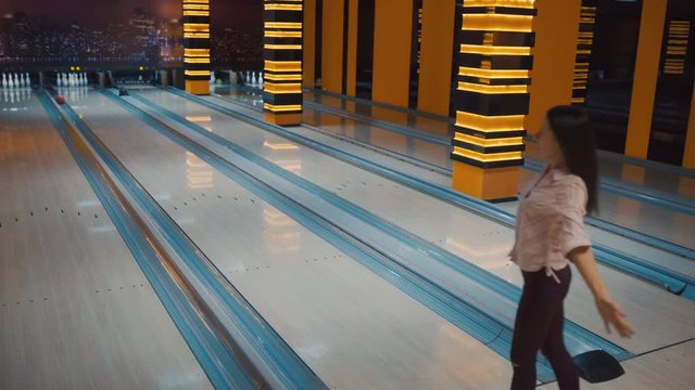 Friends bowling at club and having fun playing casually