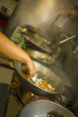 chef's hands preparing salad on the spit