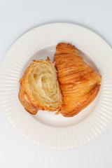 Freshly baked traditional croissant cut into two parts