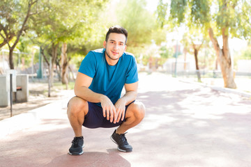Confident Young Man Taking Break After Running In Park