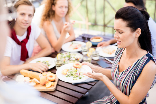 Portrait Of Frustrated Woman Complaining About Food During Lunch With Friends In Cafe, Copy Space