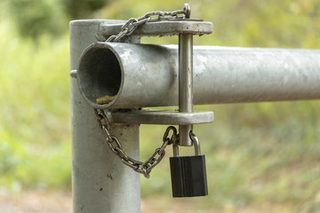 Vorhängeschloss an einer Schranke an einem Feldweg