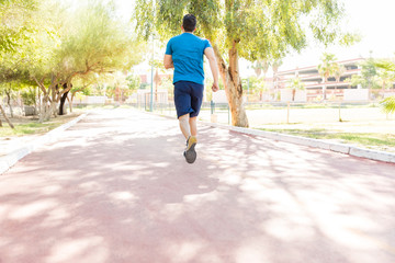 Male Athlete Sprinting On Road In Park