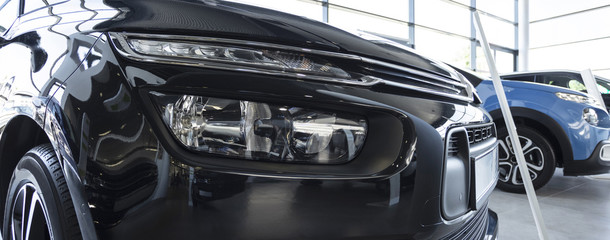 Fototapeta premium Close-up of front of black exclusive car in the showroom