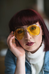 Portrait of young redhead with denim jacket turtle neck and glasses