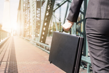Close up business woman holding black briefcase on the metal bridge walking to work, go to target and goal concept